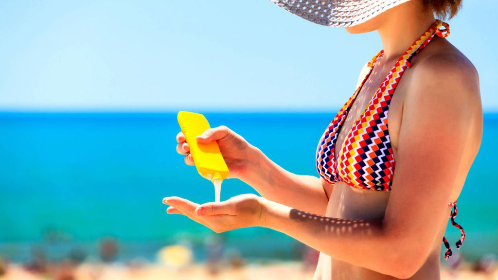 Mujer poniéndose crema solar