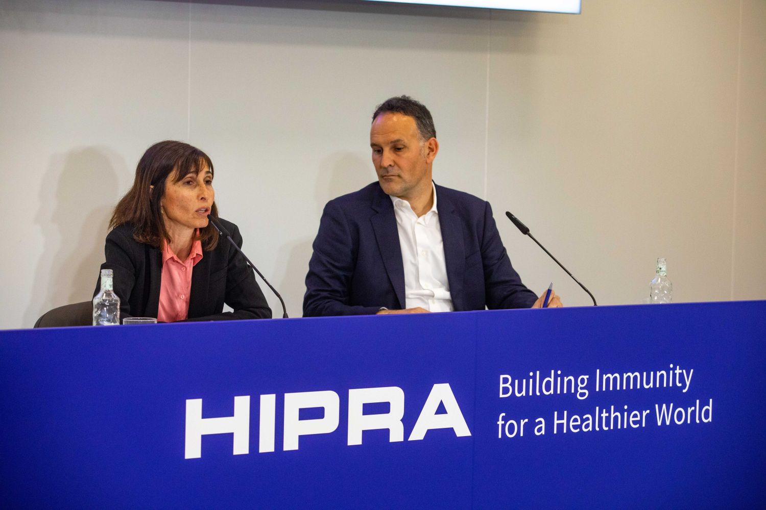 La vicepresidenta ejecutiva y directora de I+D y Registros de la farmacéutica, Elia Torroella, y el director de la División de Salud Humana de Hipra, Carles Fàbrega, durante una rueda de prensa en la sede de Hipra, a 30 de marzo de 2023, en Amer, Girona, Cataluña (España). La farmacéutica catalana Hipra ha anunciado que pedirá la autorización de su vacuna a países de fuera de Europa una vez el Comité de Medicamentos de Uso Humano de la Agencia Europea de Medicamentos (EMA) ha dado su visto bueno a la autorización de su vacuna contra la Covid-19, conocida como 'Bimervax'.