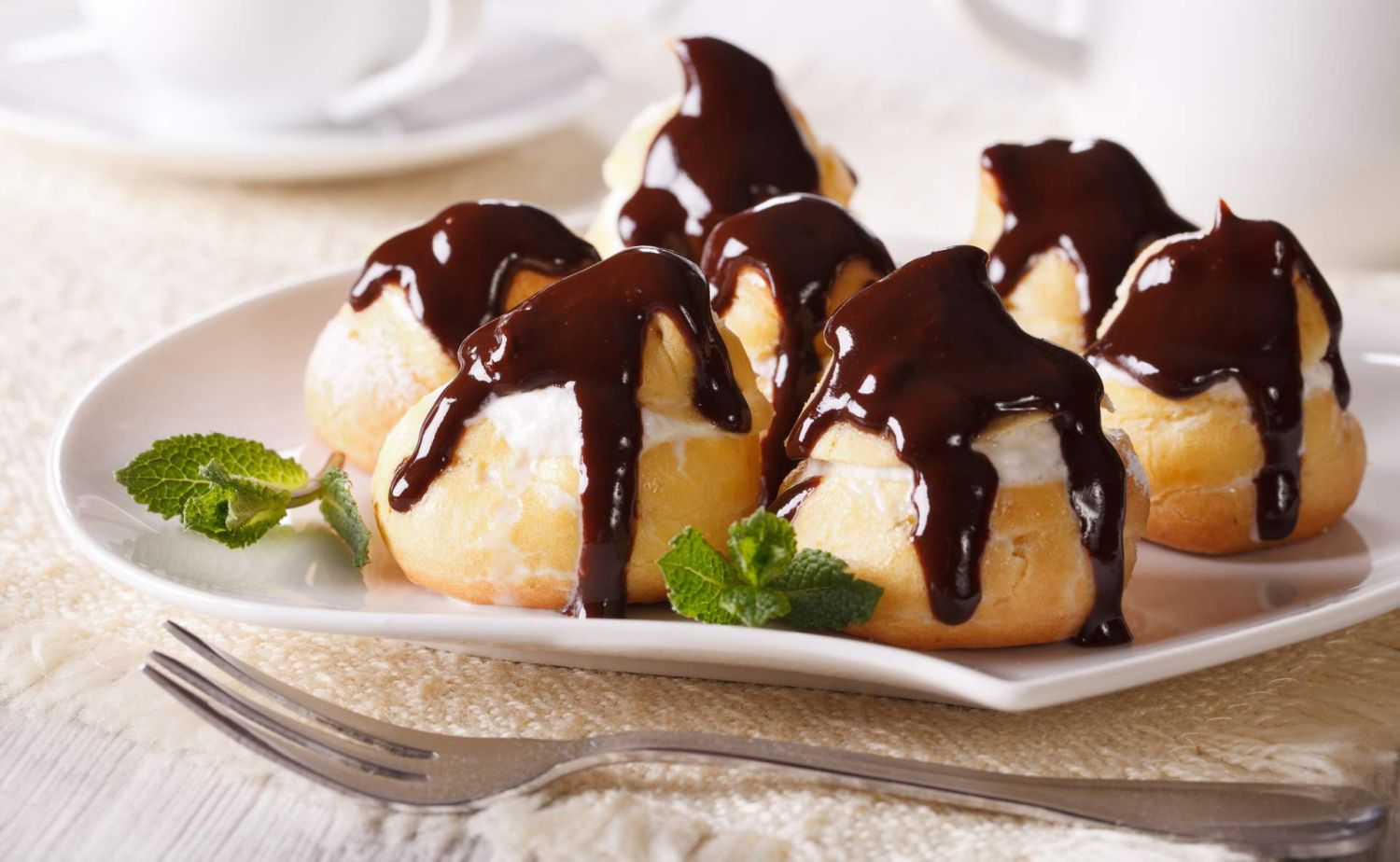Sorprende a todos con estos profiteroles rellenos de nata y cubiertos con chocolate