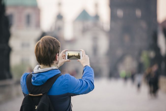 Una turista fotografía el Puente de Carlos en Praga con su smartphone