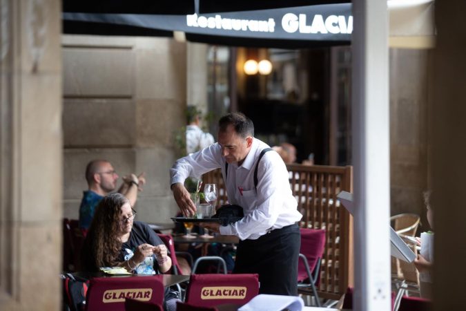 Un camarero limpia una mesa.