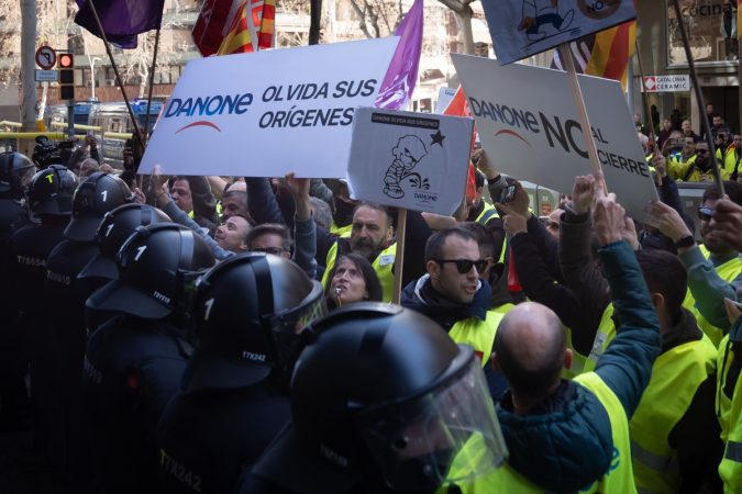 Manifestantes frente a antidisturbios durante una protesta contra el cierre de la planta de Danone en Parets del Vallès, a 12 de febrero de 2024, en Barcelona, 