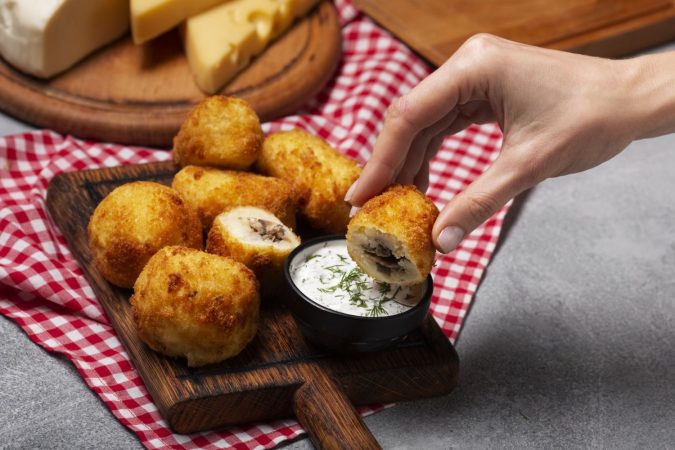 close up hand holding food croquette Merca2.es