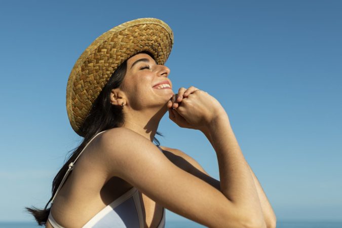 smiley woman posing beach side view Merca2.es