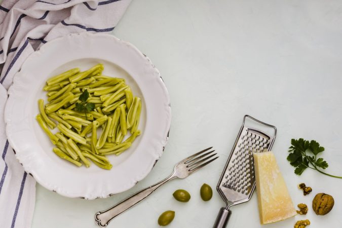 spinach gemelli pasta white ceramic plate with ingredients white backdrop Merca2.es