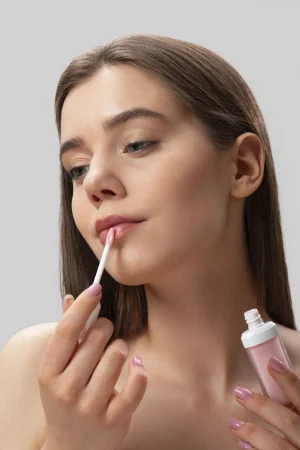 front view woman using lip gloss Merca2.es