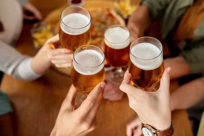 closeup friends toasting with beer Merca2.es