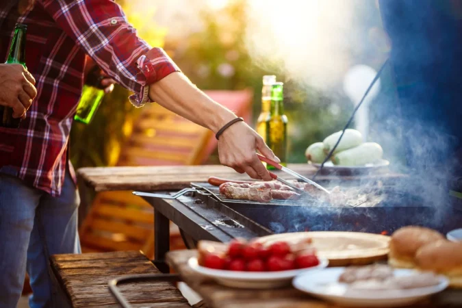 young men roasting barbecue grill cottage countryside Merca2.es