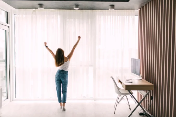 young pretty woman stretching home front window morning Merca2.es