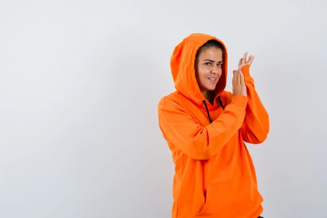 female orange hoodie posing while standing looking alluring Merca2.es