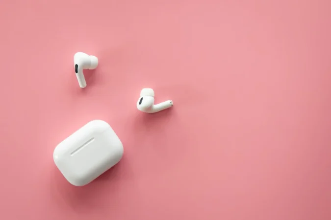 wireless inear headphones with case pink background flat lay Merca2.es