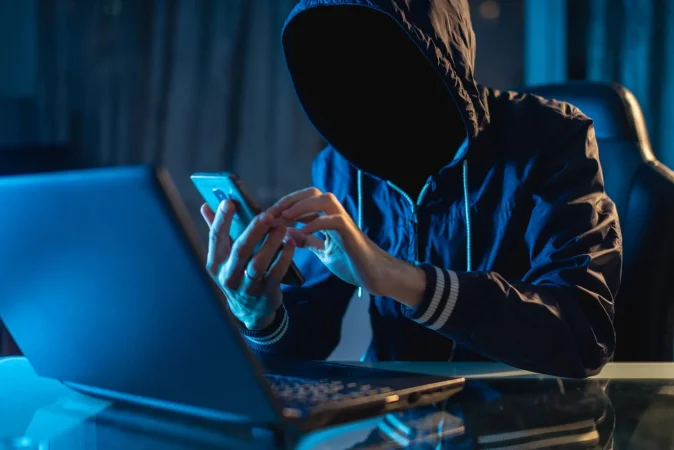 anonymous hacker programmer uses laptop hack system dark concept cybercrime hacking database Merca2.es