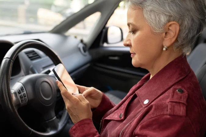 confident mature businesswoman stylish jacket chats with her smartphone inside car Merca2.es