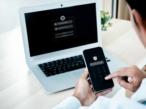 two factor authentication 2fa concept safety shield icon while access phone with laptop validate password identity verification cybersecurity with biometrics authentication technology Merca2.es