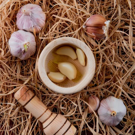 Mejor prevenir que curar con estos trucos para eliminar las hormigas de casa 3 Merca2.es close up view peeled garlic cloves garlic crusher garlic bulbs straw background Merca2.es