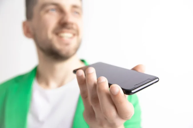 indoor portrait attractive young man holding smartphone Merca2.es