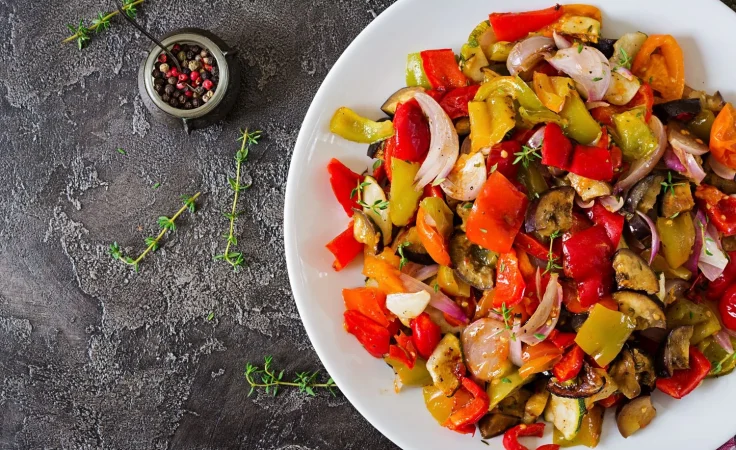 baked vegetables white plate eggplant zucchini tomatoes paprika onions top view Merca2.es