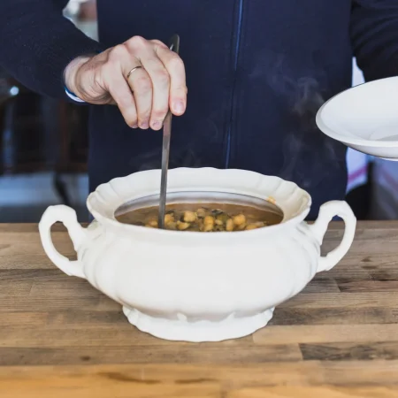 elderly hands putting tasty soup plate kitchen 1 Merca2.es