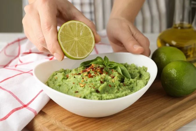Guacamole casero: El acompañante perfecto para tus aperitivos 2 Merca2.es female hands hold lime bowl with guacamole Merca2.es