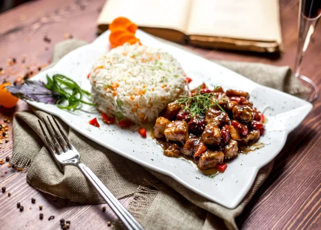side view fried meat sauce with dried fruits rice Merca2.es