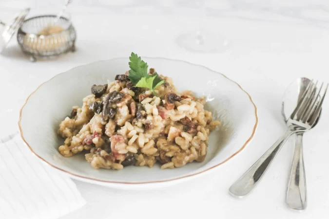 risotto de arroz con champinones sobre plato de ceramica blanca Merca2.es