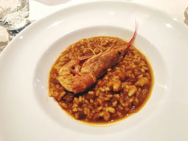 Arroz caldoso con bogavante o carabineros: Un verdadero manjar del mar 2 Merca2.es vision en angulo alto de los alimentos en el plato Merca2.es