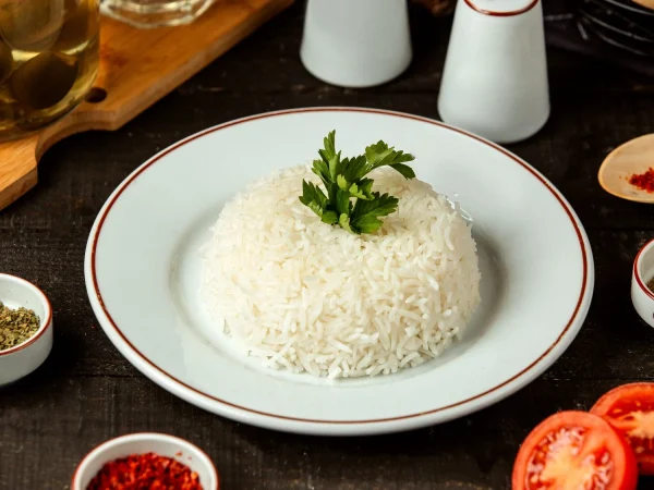 vista lateral de un plato con arroz cocido con perejil sobre la mesa Merca2.es