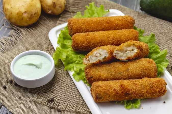 vista lateral nuggets de pollo en lechuga con salsa y papas sin pelar Merca2.es