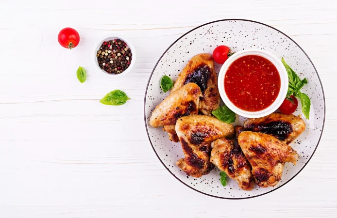 alitas de pollo al horno al estilo asiatico y salsa de tomate en un plato Merca2.es