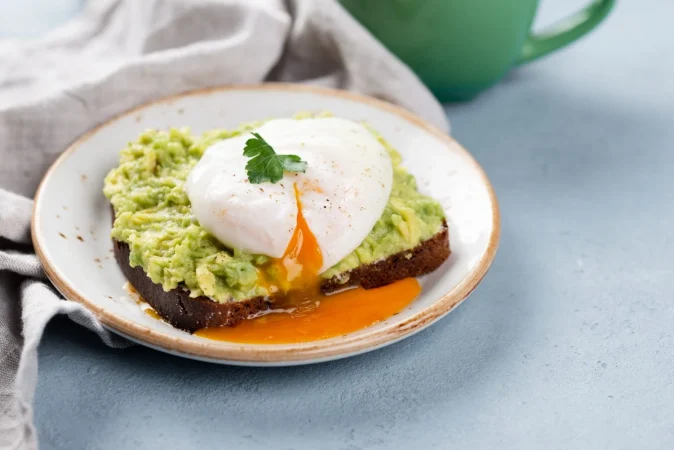 alto angulo de tostadas de aguacate con huevo escalfado Merca2.es