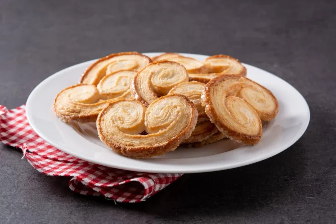 hojaldre palmier en placa sobre fondo de pizarra negra Merca2.es
