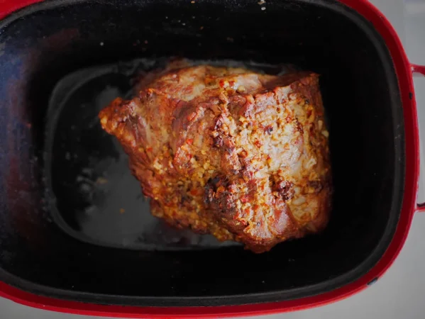 Pierna de cerdo al horno: El secreto de una piel crujiente y una carne jugosa 4 Merca2.es primer plano de la carne en el recipiente Merca2.es