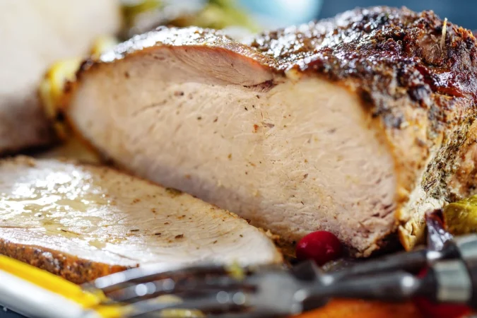 Pierna de cerdo al horno: El secreto de una piel crujiente y una carne jugosa 1 Merca2.es sabrosa y apetitosa carne de cerdo asada con verduras para navidad o el dia de accion de gracias de cerca Merca2.es