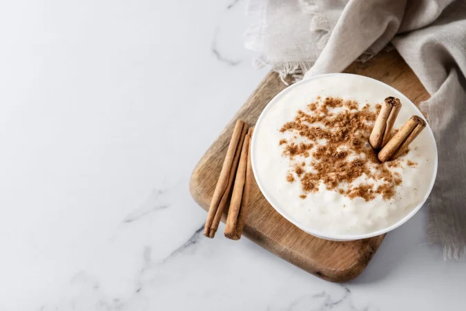 arroz con leche pudin de arroz con canela en un cuenco de arcilla sobre marmol blanco vista superior 1 Merca2.es