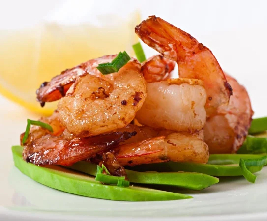 camarones salteados con ajo y salsa de soja sobre un cojin de rodajas de aguacate 2 Merca2.es