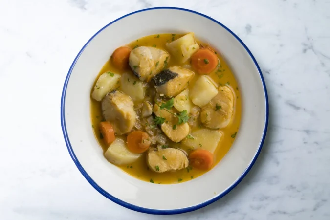 estofado de hake con patatas y zanahorias mesa de vista superior con decoraciones Merca2.es