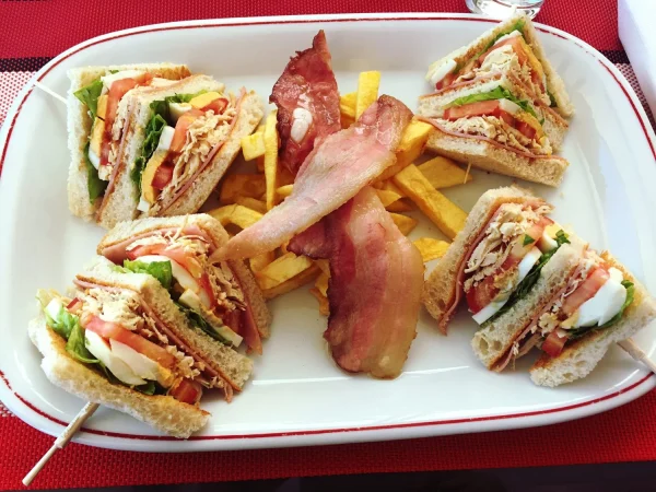 Cómo preparar tu propio sándwich club casero de varios pisos, tan rico como los que te sirven en el Vips 5 Merca2.es primer plano de los alimentos en el plato 1 Merca2.es