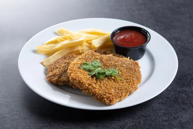cachopo comida tradicional de asturias espana carne de filete en pan sobre un fondo de pizarra negra Merca2.es