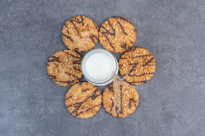 galletas de semillas de sesamo recien horneadas y leche en la mesa de marmol Merca2.es