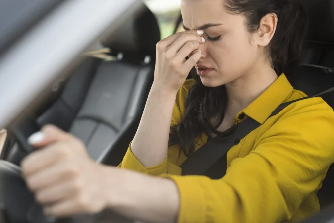 mujer conduciendo y teniendo dolor de cabeza Merca2.es