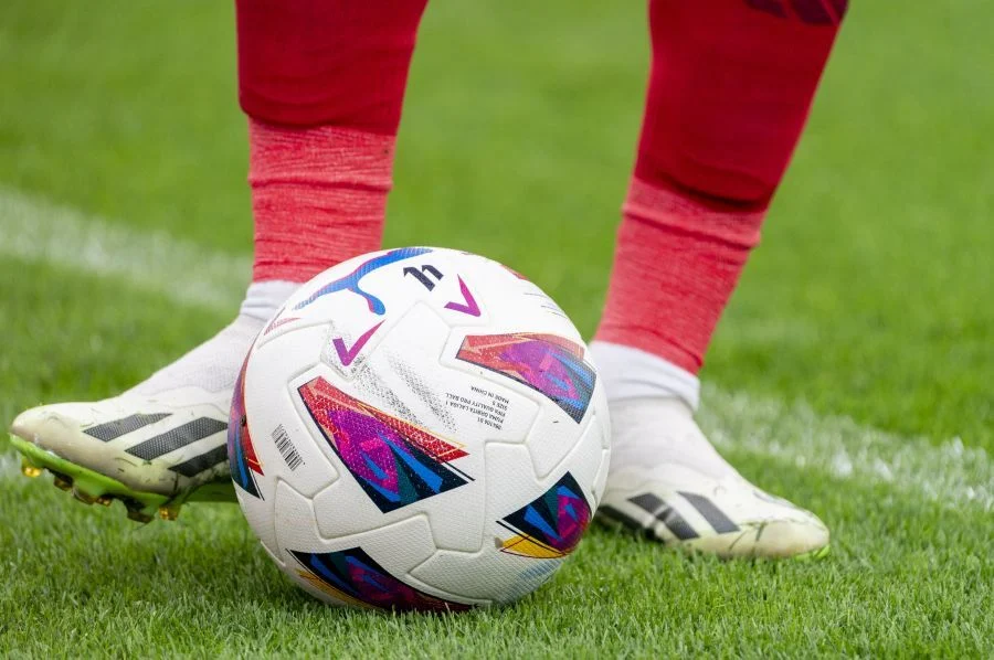Los pies de un futbolista tocan el balón sobre el césped de un estadio de fútbol | Foto de LALIGA