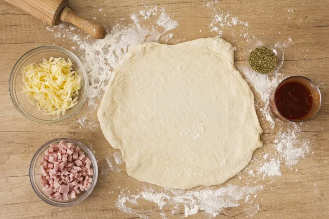masa de pizza plana con salsa de tomate mozzarella y jamon Merca2.es