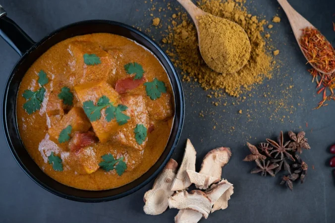 Pollo al curry: receta, secretos y curiosidades del plato que conquista a medio mundo 5 Merca2.es massaman curry en una sarten con especias en el piso de cemento 1 Merca2.es